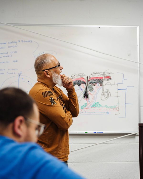 Fade Fellas Barber School instructor teaching a classroom barbering lesson.