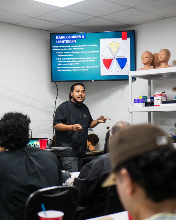Owner / Instructor Eddie, teaching a barbering class to students at Fade Fellas Barber School.
