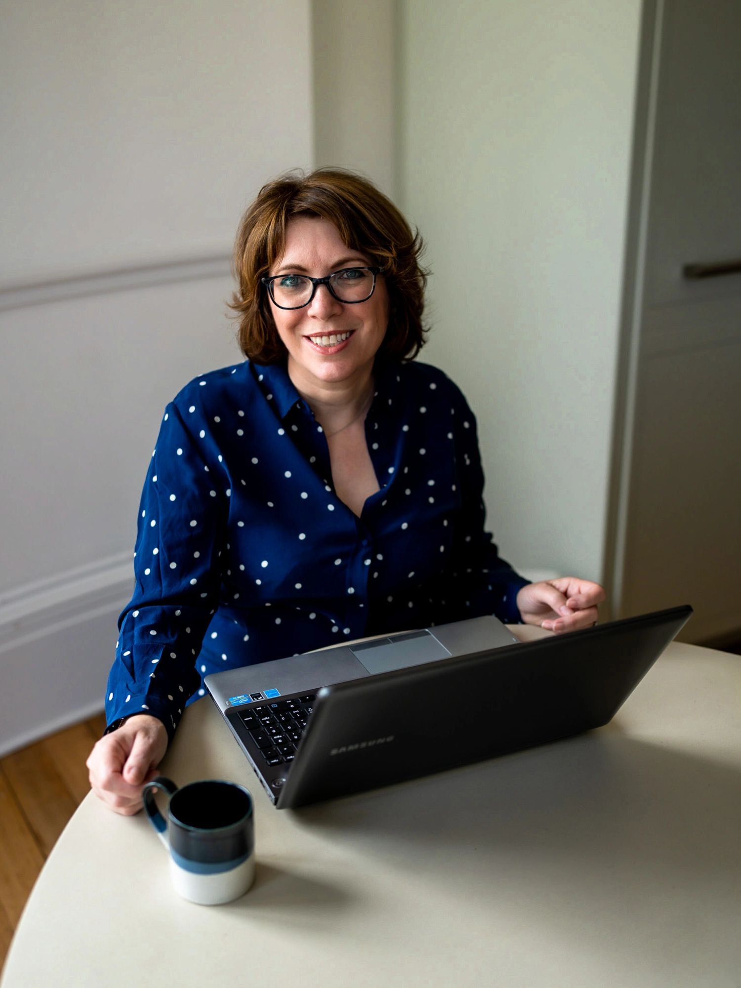Jane Griffin, founder and director of Positive Story PR Consultancy with a laptop and mug.