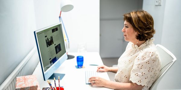 Jane Griffin, founder and director of Positive Story PR consultancy sitting at her desk working.