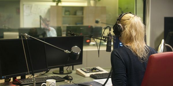 Photo of radio presenter and producer in radio studio