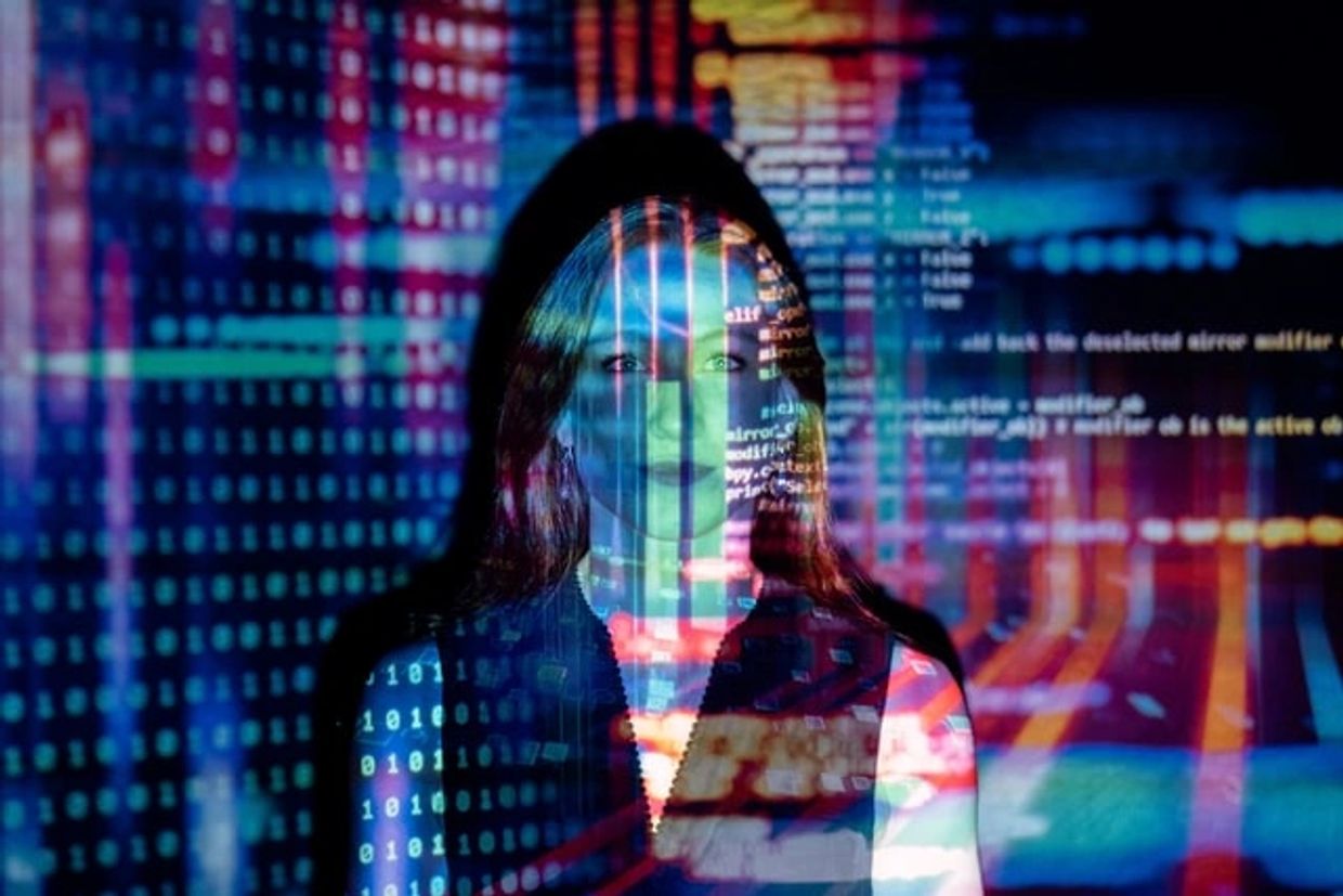 A female engineer against a screen of computer data.