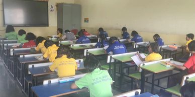 Students sitting and writing in a classroom.