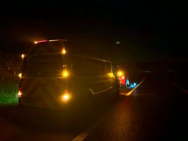 Van with hazard lights on at night on the roadside.