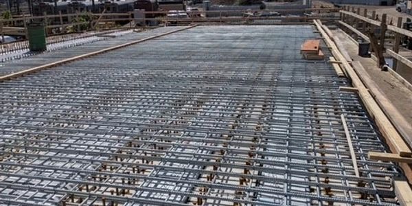 Construction site showing steel reinforcement for concrete floor.