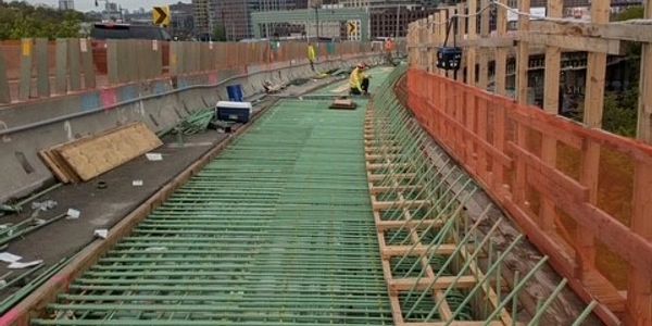 Bridge under construction with reinforcement bars and worker.