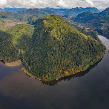 A lush green forested peninsula surrounded by calm waters.