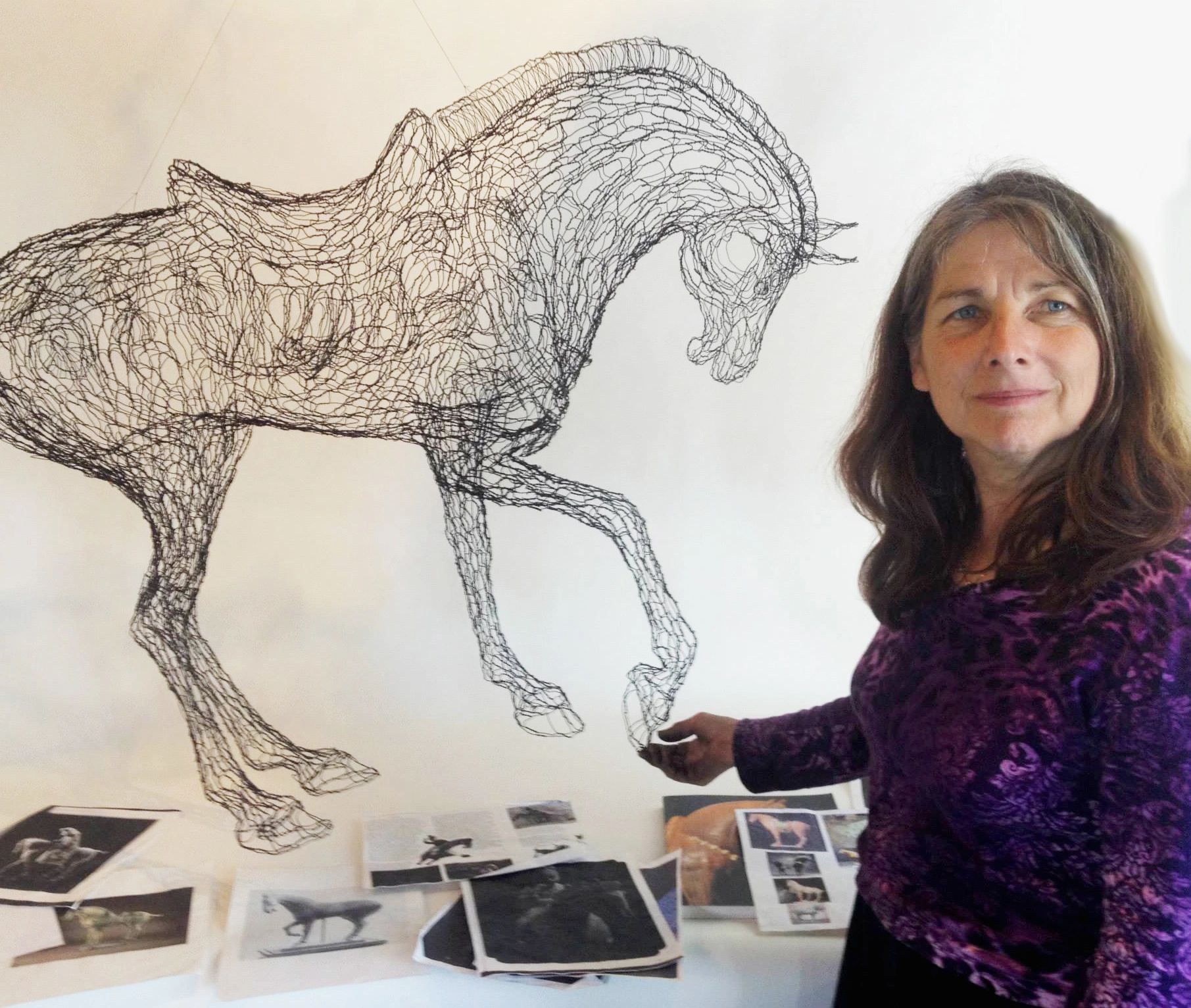 Elizabeth Berrien with Tang Horse wire sculptures, in the studio with reference images
