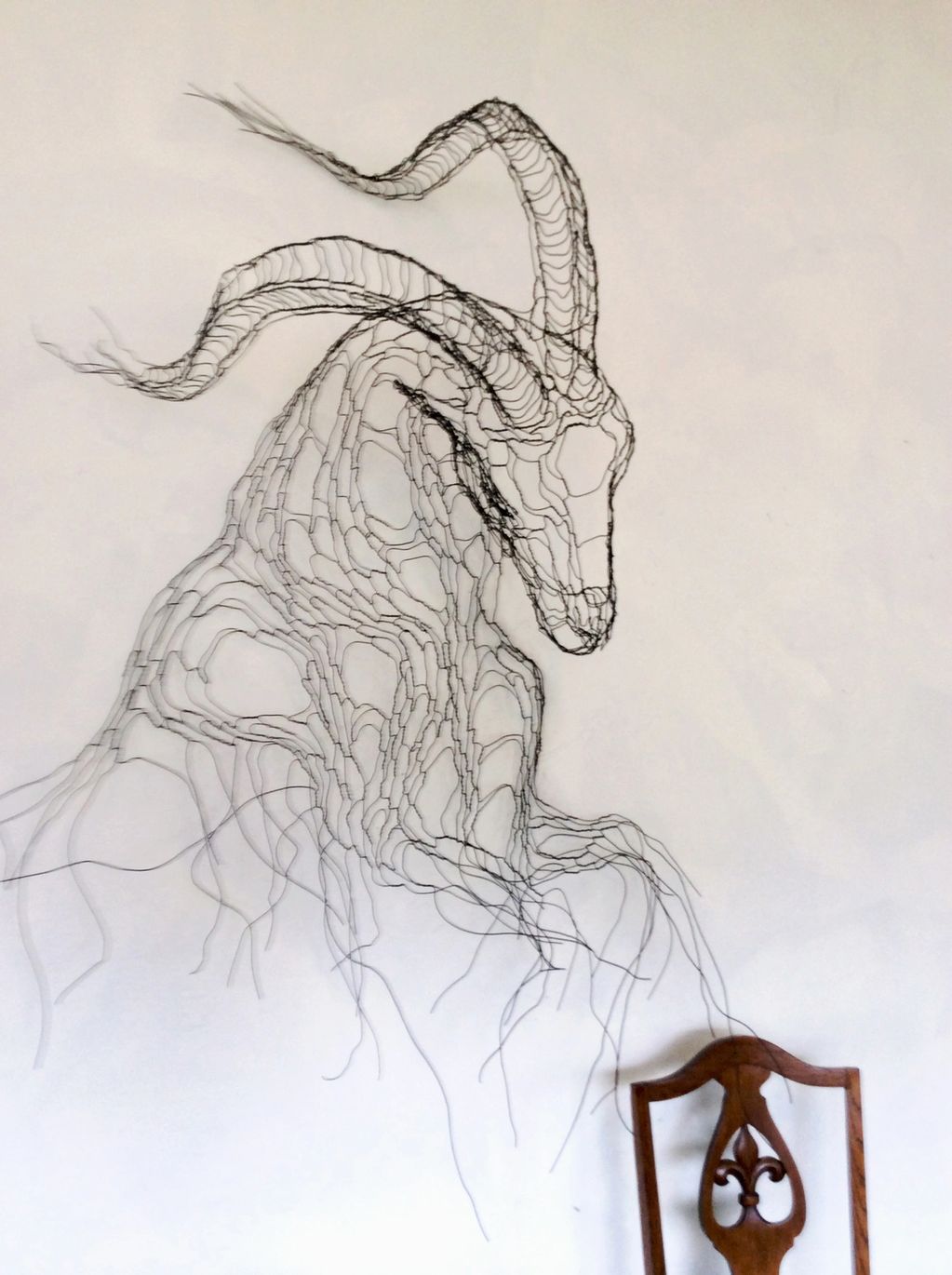 Ibex wire sculpture wall art. Created for installation on a backward-sloping wall, the head and horn