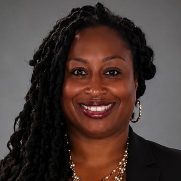 Professional woman with braided hair smiling.