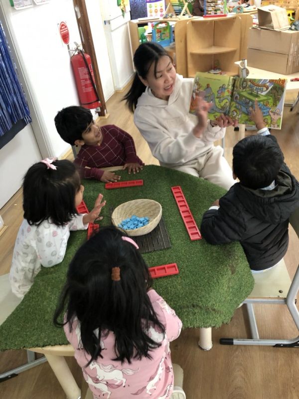 Educator using intentional teaching with children during a small-group learning experience at Seven Stars Wentworthville