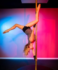 A woman practicing pole dance in professional way