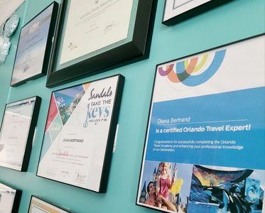 Travel agent's wall in her office showing all different certifications she has aquired over the year