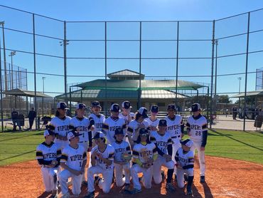 Youth baseball team posing for a group photo on the field.