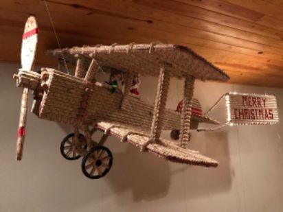 Model airplane made of corks with "Merry Christmas" sign.