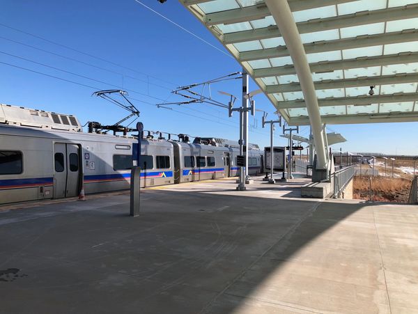 Westminster Station platform with a train on the left and the canopy of steel and glass above.