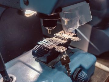 locksmith using a key machine cutting new house and car keys