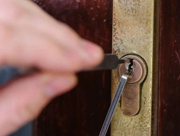 locksmith picking open a locked out door lock