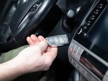 man using a remote start car key fob