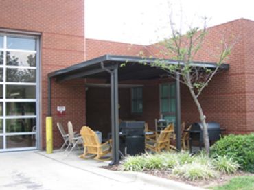 Attached rolled formed aluminum flat-pan cover at a fire station bronze color with Ivory pans