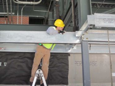 Construction worker inspecting a steel beam.