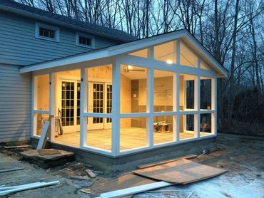 A sunroom addition under construction attached to a house.