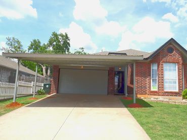 attached 24ft X 20ft attached galvanized steel full boxed framed singled slopped design carport.
