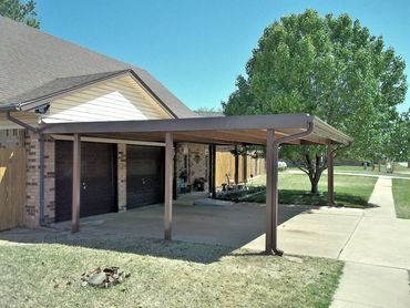Attached 24ft x 20ft structual steel carport with 26ga steel and bent trim 6-poles painted brown