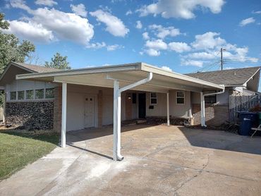30ft X 20ft 3-car open span attached flat-pan carport with 10-inch C-beams and 4" core drilled pole
