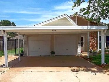20x20ft aluminum attached flat-pan carport that has built in guttering system. White in color. OKC