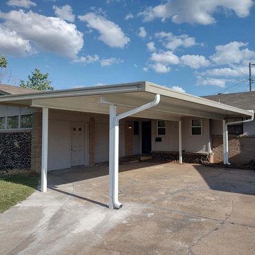 30ft/20ft attached open span aluminum carport using 10inch I-beams and core drilled poles. OKC