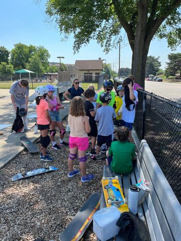 Skaters getting stickers at the end of Park Ridge Skateboard Camp