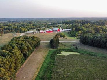 Drone aerial photo of a farm with a red barn and green field in Minnesota.
