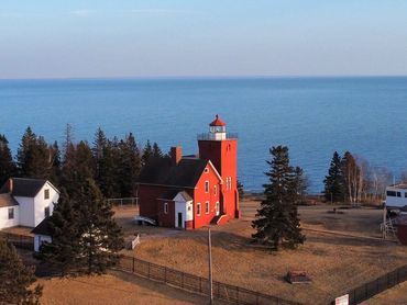 Drone photo of red lighthouse on the shore of Lake Superior in two harbors in Minnesota.
