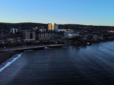 Aerial drone photo of the city of Duluth, Minnesota with tall buildings and Lake Superior.