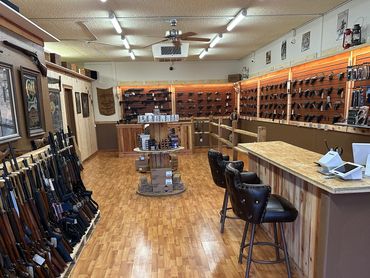 Interior of a gun store with rifles and handguns displayed.