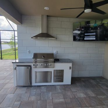 Prestige - Customer purchased pre-fab grill, we tiled entire wall and installed hood and TV.