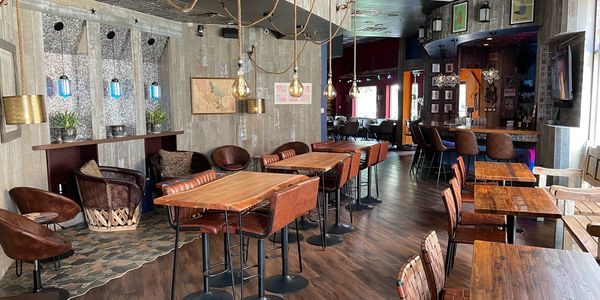 Lively atmosphere with cozy lounges, vibrant bar, fun music, and outdoor seating.
