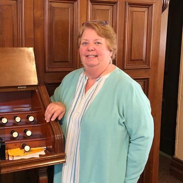 Joyce, church organist/accompanists standing next to organ