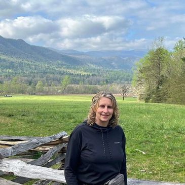 Women's ministry coordinator standing in field with mountains in background