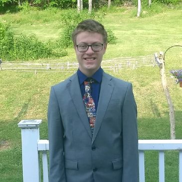 Matt Randles in suit and tie standing outside