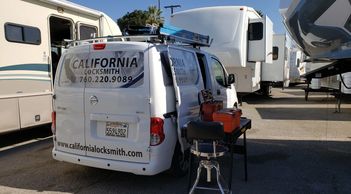 The California locksmith van in front of several RVs. A mobile tool bench set up and ready to work.