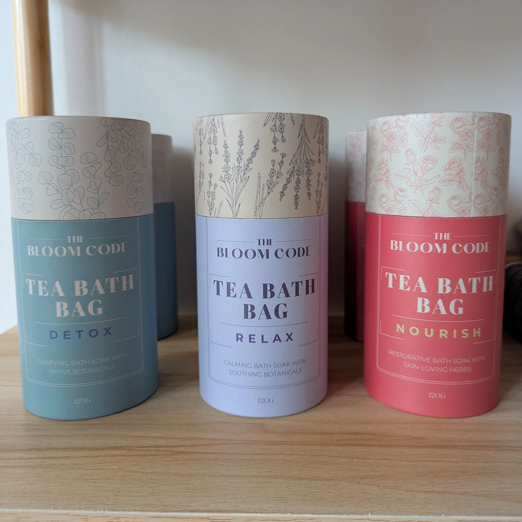 Three types of tea bath bags on a wooden shelf.