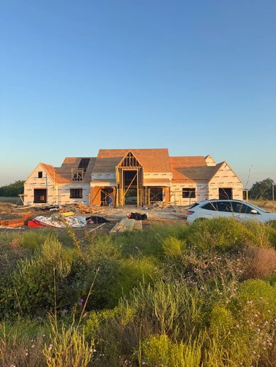 Large house under construction with clear blue sky.