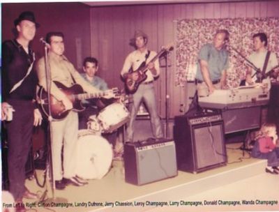 Vintage photo of a six-member band with instruments in a cozy room.
