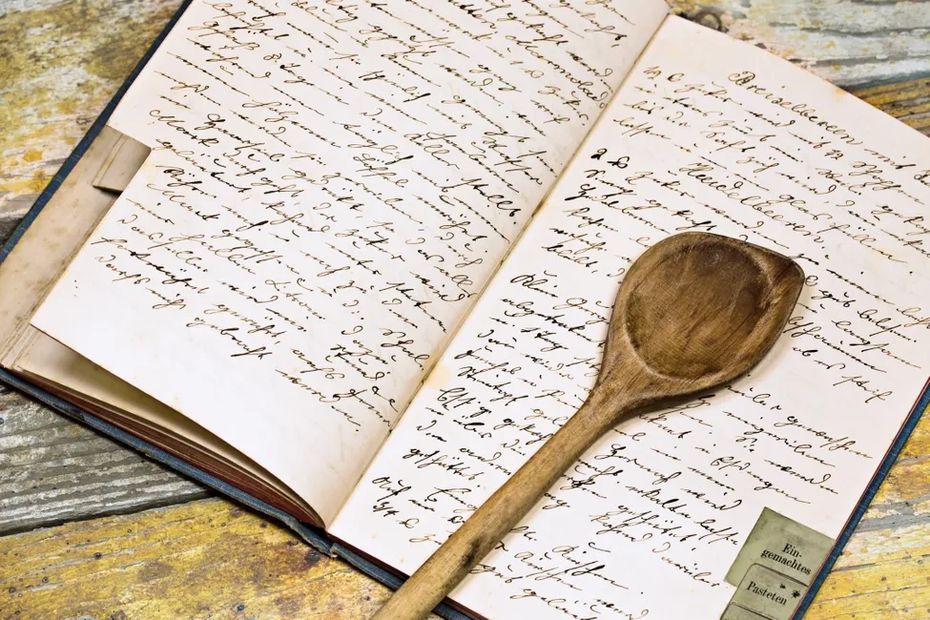 A wooden spoon on an open recipe book