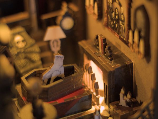 Miniature spooky room with coffin and eerie decorations.