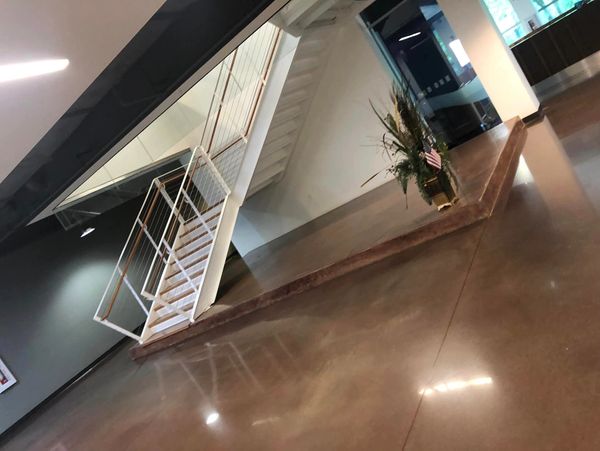Indoor staircase with glass railing and polished floor in modern building.