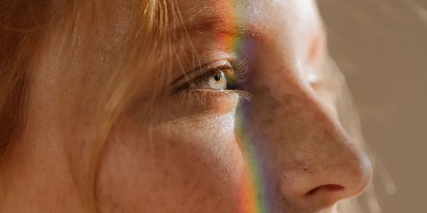 Glowing Face and skin reflecting a glimmering rainbow.