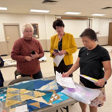 Guild members reviewing a mystery quilt block.
